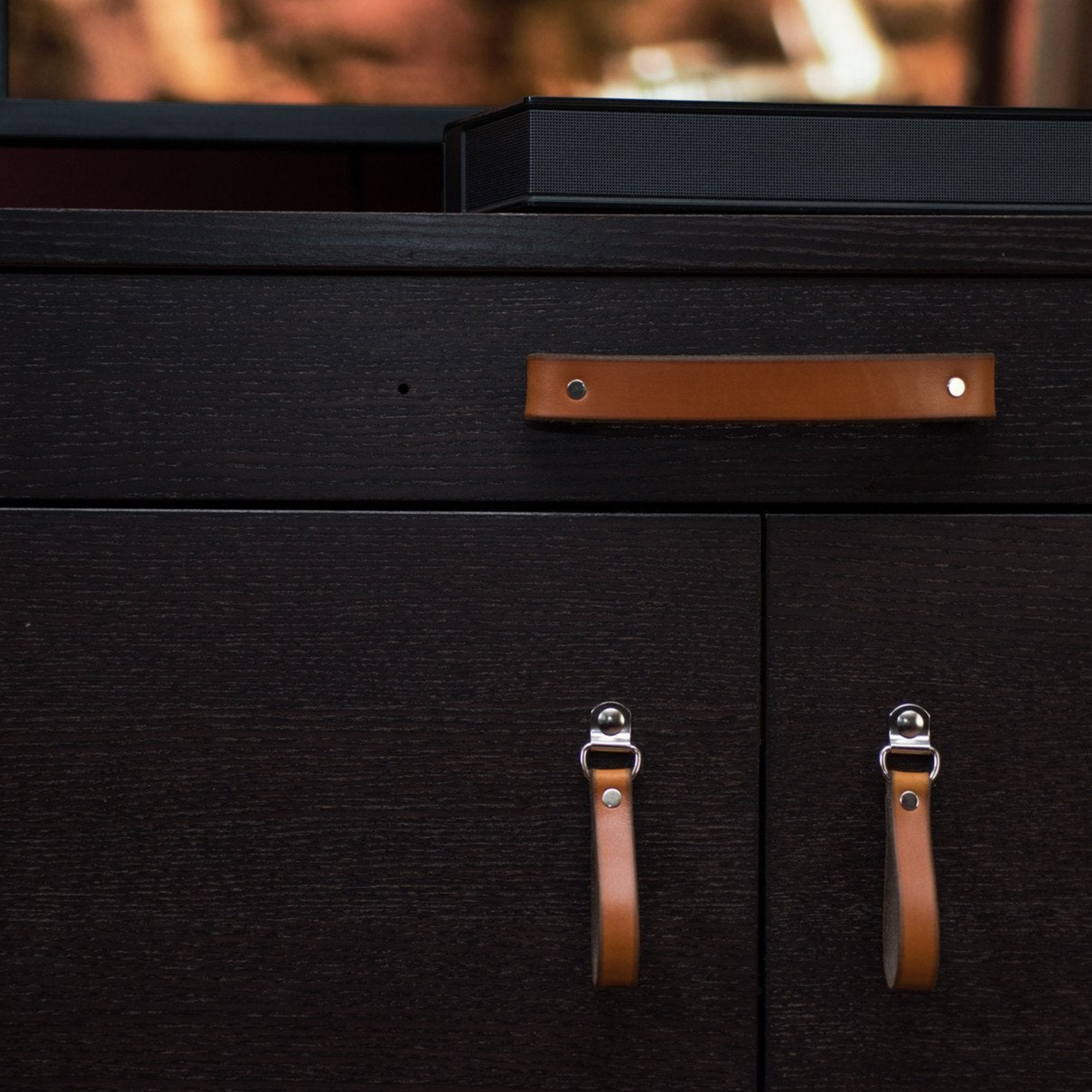 IKEA television stand furniture in black-brown with honey leather handles as a pretty contrast color