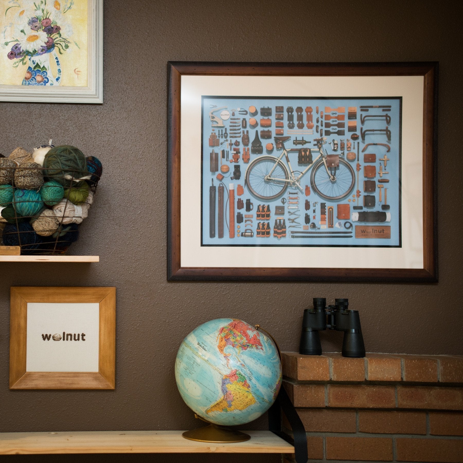 A framed poster of bicycle accessories displayed on a brown wall