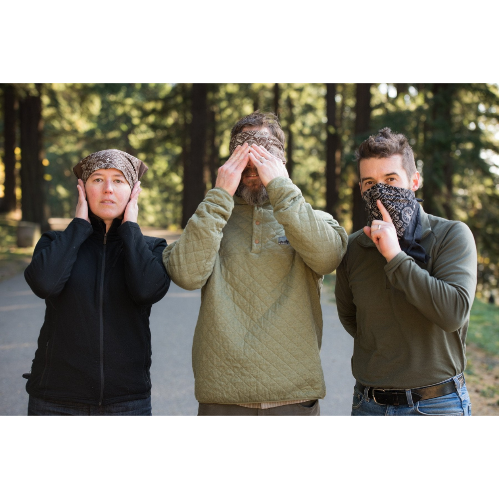 Three people standing in a line wearing a brown bicycle print bandana, one over their ears, one over their eyes, and one over their mouth