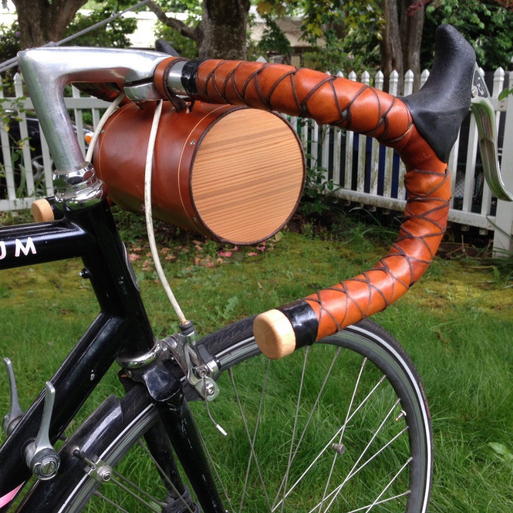 Side view of honey leather bag showcasing the wooden end pieces displayed on bicycle handlebars