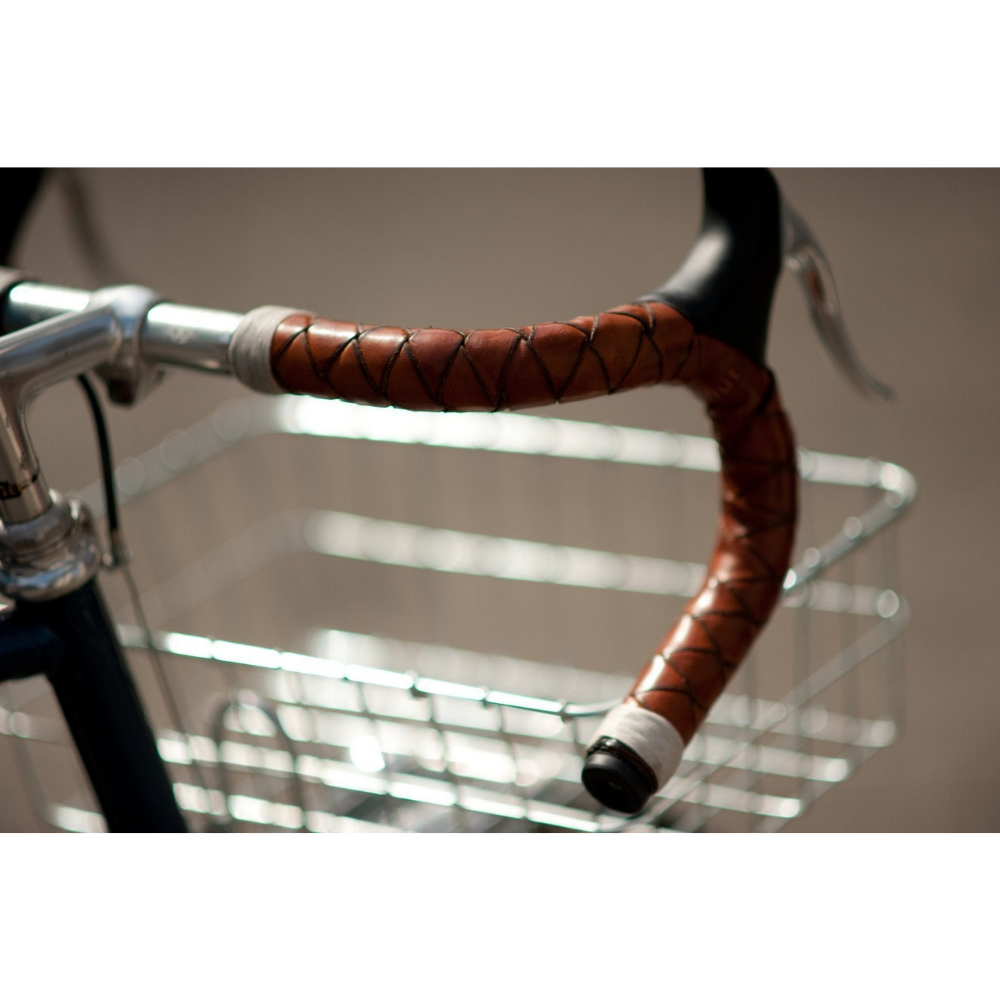 Close-up photo of honey braided leather bar wraps showing how cleanly it is braided underneath the brake hood on the drop bar. 