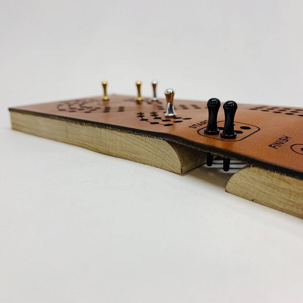 Close-up Photo of Unfolded Leather Travel Cribbage Board Game in Play. Shows Pegs Reach Down to the Hilt for Travel Safety.